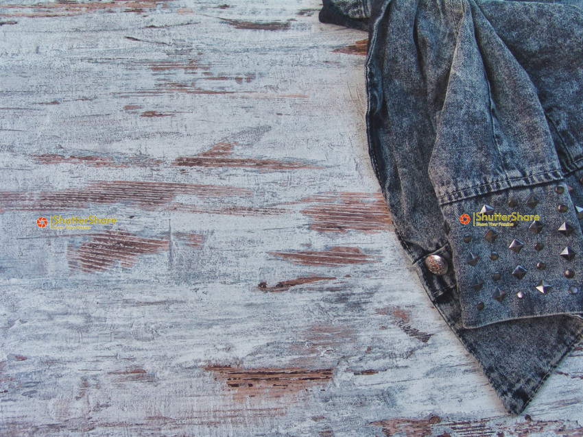 Studded Denim Jacket on Distressed Wooden Surface