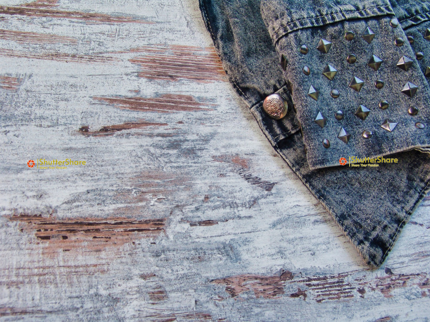 Close-Up of Studded Denim Jacket on Distressed Wooden Surface