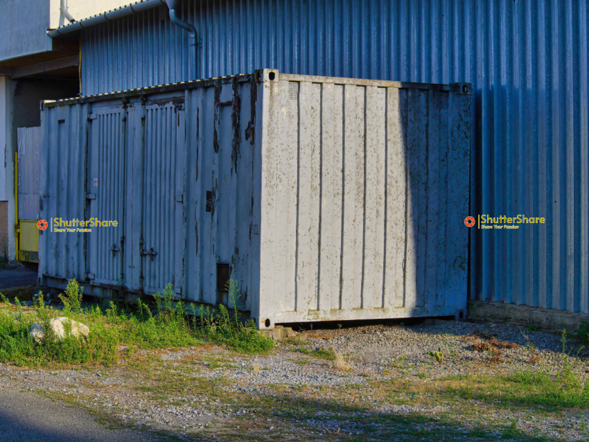 Weathered Shipping Container Against Building